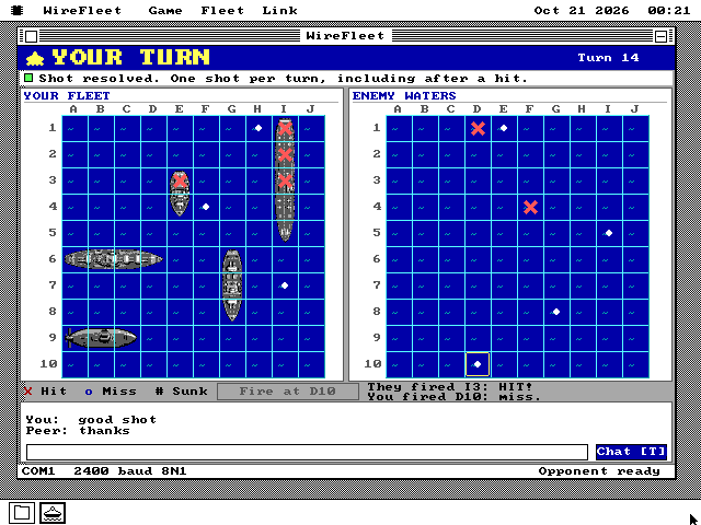 The same battle on the second PC. The banner reads YOUR TURN, Turn 14. Its own fleet on the left has three red crosses down a carrier in column I and one on a ship at E3. Its enemy waters on the right show two red crosses and five white dots. The chat log reads You: good shot and Peer: thanks, and the status bar shows COM1, 2400 baud 8N1.